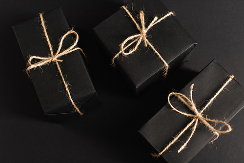 top view of wrapped dark gift boxes on black