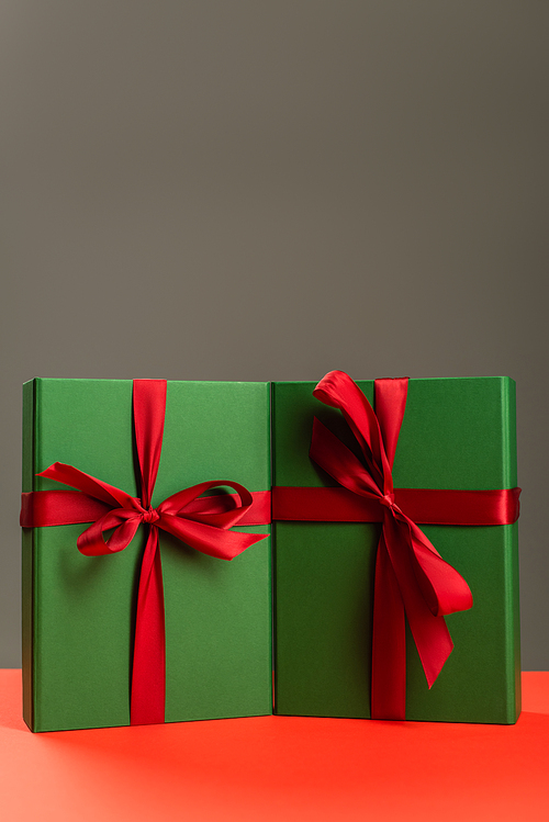 green wrapped presents on red surface isolated on grey