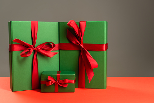 green wrapped presents with red ribbons isolated on grey