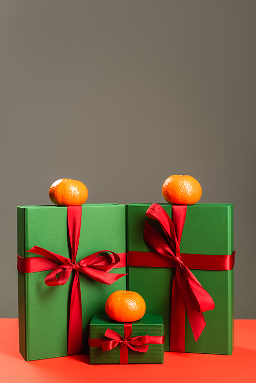 tangerines on green wrapped presents isolated on grey