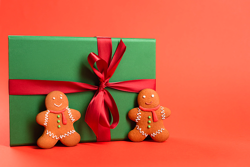 gingerbread cookies near green wrapped present on red