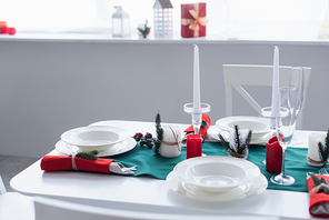table with white tableware and christmas decoration served for festive dinner