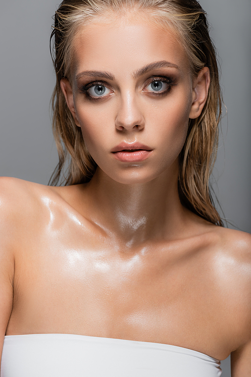 pretty woman with wet skin and hair  isolated on grey
