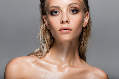 blonde woman with wet, bare shoulders  isolated on grey