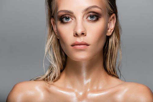 blonde woman with wet body and hair  isolated on grey