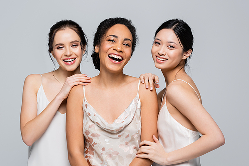 Smiling multiethnic women posing and  isolated on grey