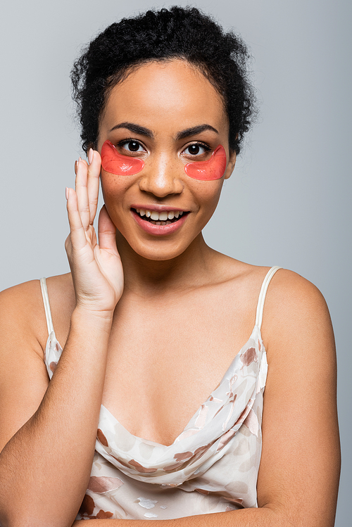 Happy african american woman with eye patches  isolated on grey