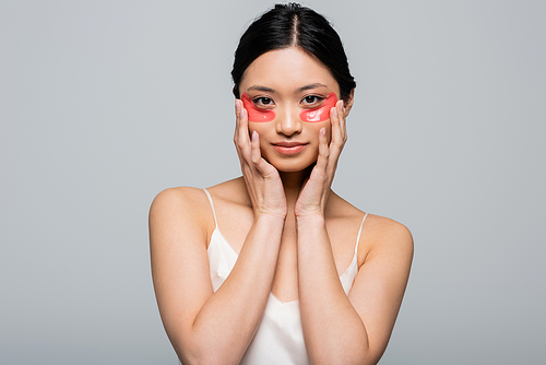 Pretty young asian woman with eye patches  isolated on grey