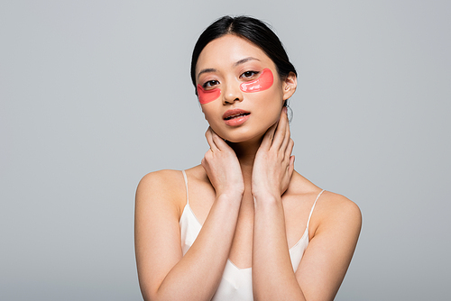 Asian woman in sating dress and eye patches  isolated on grey