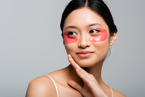 Portrait of young asian woman in eye patches isolated on grey