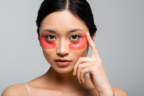 Pretty asian woman in eye patches  isolated on grey