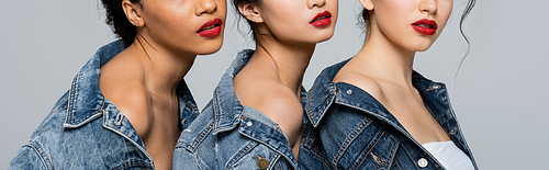 Cropped view of interracial women in denim jackets isolated on grey, banner