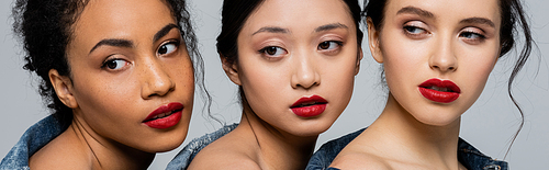 Pretty multiethnic women with red lips looking away isolated on grey, banner