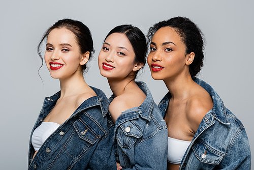 Smiling multicultural women with red lips  isolated on grey