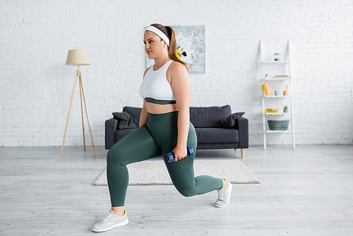 Brunette woman with overweight doing lunges with dumbbell at home