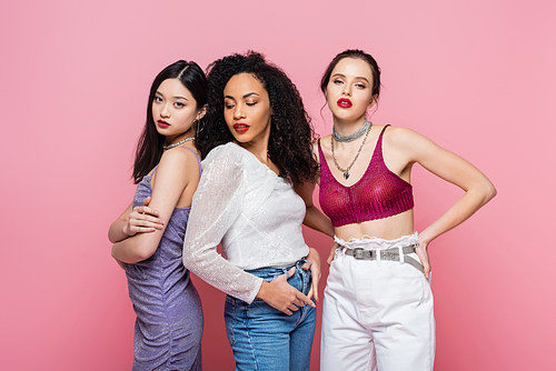 Young multiethnic women posing during party isolated on pink