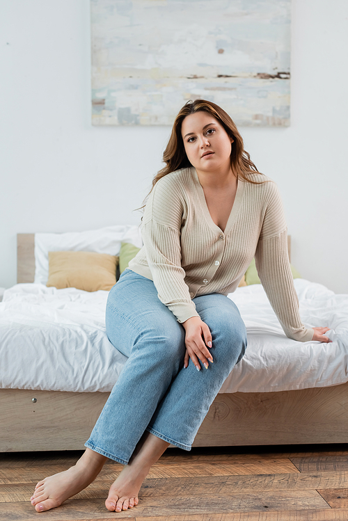 Pretty body positive woman in casual clothes  on bed