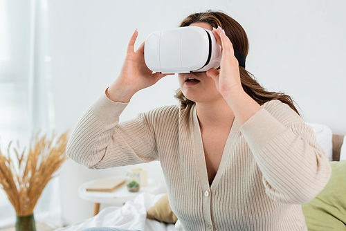 Young woman with overweight using virtual reality headset at home