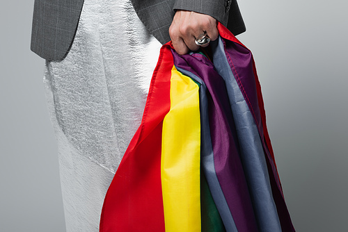 cropped view of transsexual man in slip dress holding lgbt flag isolated on grey