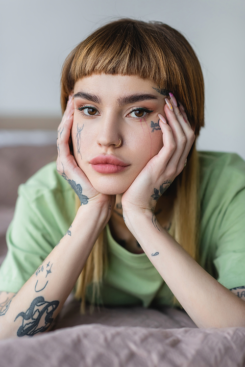 pretty young woman with tattooed face and hands  at home