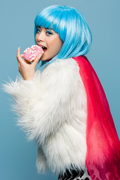 Asian woman in pop art style eating donut and  isolated on blue