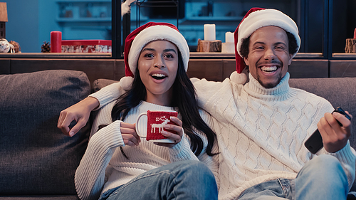 excited african american couple watching movie on christmas
