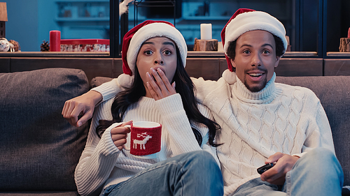 amazed african american couple watching movie on christmas