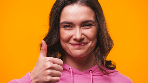 happy woman showing thumb up while  isolated on yellow