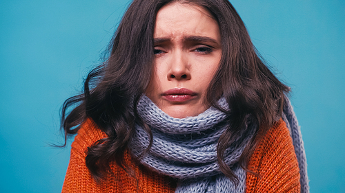 sick woman in warm scarf  while suffering from pain in throat isolated on blue