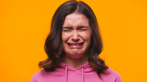 frustrated woman crying isolated on yellow