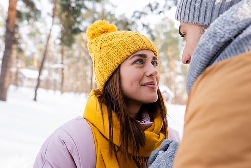 Smiling woman looking at boyfriend in winter park