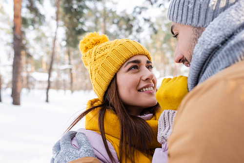 Smiling man hugging girlfriend in winter outfit outdoors