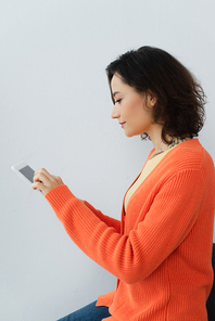 side view of young woman using digital tablet at home