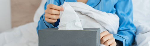 cropped view of young woman reaching napkin in tissue box, banner