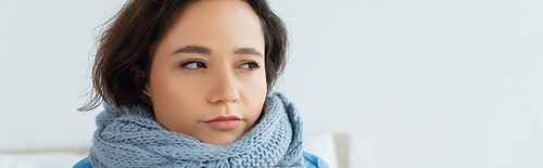young woman in knitted scarf looking away, banner
