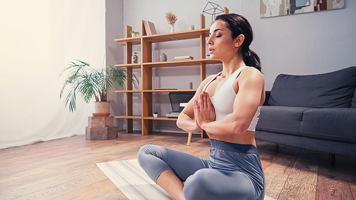 Pretty brunette woman meditating on yoga mat