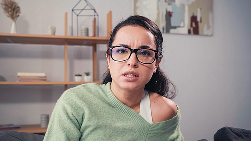 Focused woman in eyeglasses  at home
