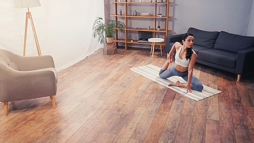 Sportswoman training on fitness mat in living room at home