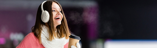 happy woman in ear muffs and scarf holding paper cup, banner