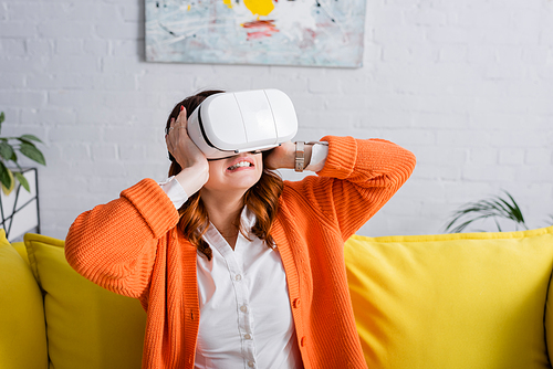 tensed woman touching head while gaming in vr headset at home