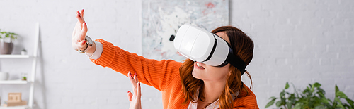 young woman in vr headset gesturing with outstretched hands, banner