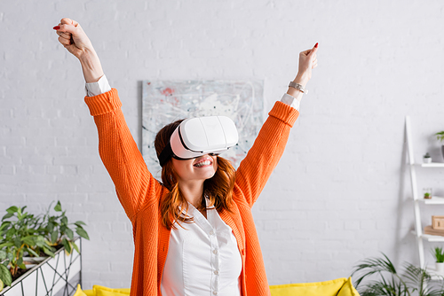 excited woman showing yeah gesture while gaming in vr headset at home