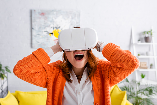 shocked woman screaming and touching head while gaming in vr headset
