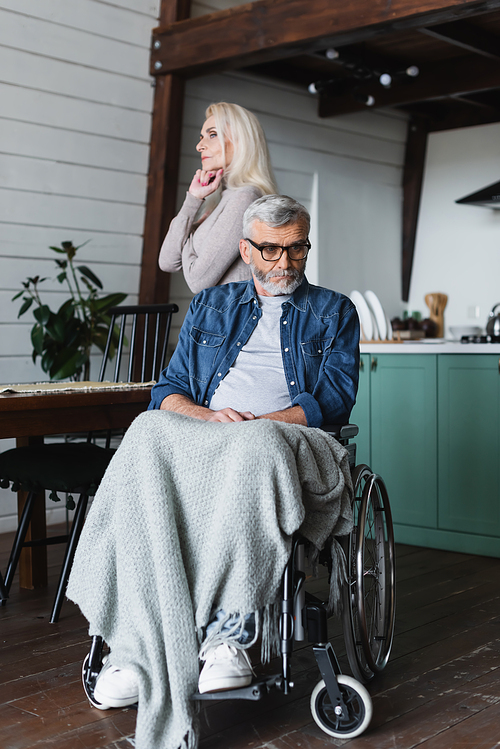 sad disabled man in . looking away near wife at home