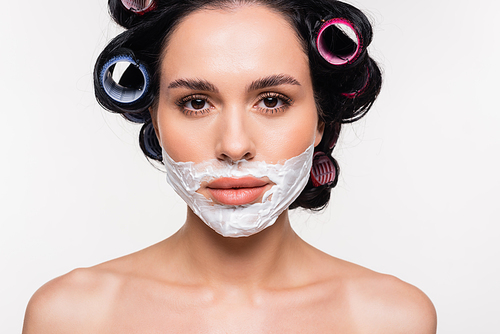 portrait of serious young woman with shaving cream on face isolated on white