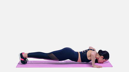 brunette young sportswoman working out on pink fitness mat on white