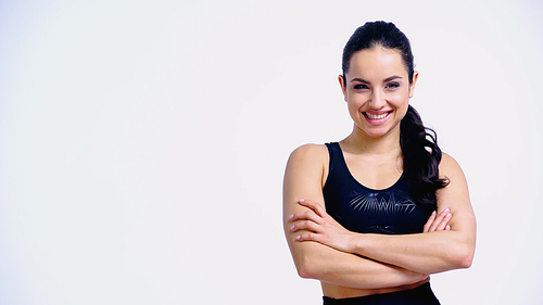 happy young woman in sportswear standing with crossed arms and  isolated on white