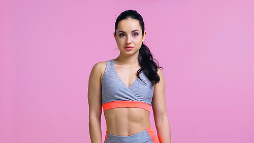 pretty sportswoman in crop top  isolated on pink