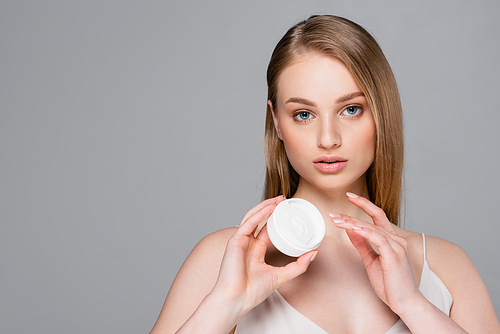 pretty woman holding container with face powder isolated on grey