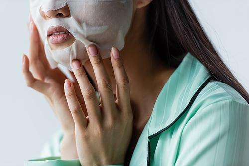 partial view of woman applying facial mask at home